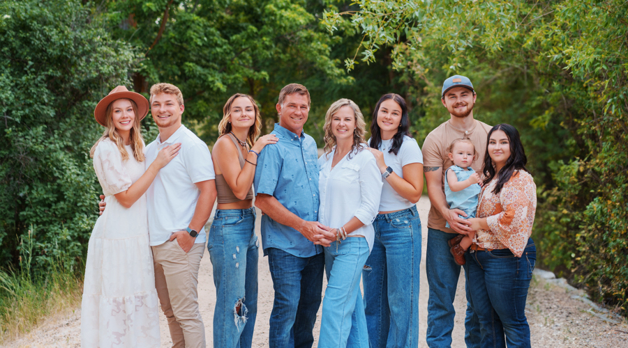 The Vineyard family standing on a gravel road in front of a forest.