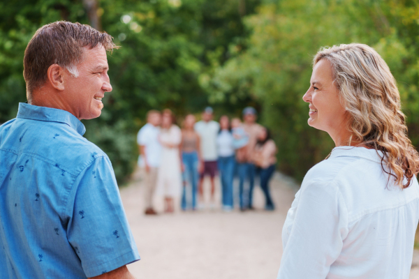 Chad and Molli Vineyard standing in front of their family on a gravel driveway in a wooded area.