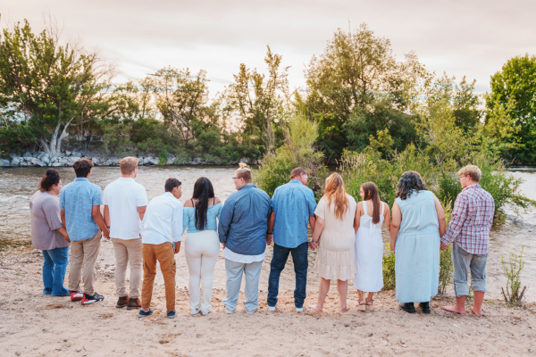 Staff members and clients facing the river and holding hands
